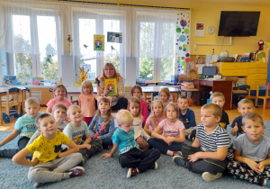 Zdjęcie grupowe – dzieci, nauczycielka, wróbelek i książka „O wróbelku Elemelku”.